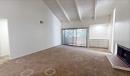 Located at 511 Q St in Sacramento's Midtown neighborhood, this single-story, 2-bedroom, 2-bathroom residence offers 910 square feet of functional living space. The living room is a standout, featuring dramatic vaulted ceilings with exposed wood beams, a wood-burning fireplace with a brick surround, and a sliding glass door that fills the room with natural light and provides outdoor access. Carpeted flooring runs throughout the living areas and bedrooms, contributing a warm, comfortable feel.

The kitchen is equipped with white cabinetry, granite-style laminate countertops, a stainless steel sink, a dishwasher, an electric range, and light wood-look vinyl flooring, offering practical functionality. Both bathrooms are finished with granite-style countertops and white vanity cabinetry, with one bathroom featuring a soaking tub accented by marble-style tile surround and wood-look vinyl flooring.

The primary bedroom measures 180 square feet and includes a sliding-door closet with built-in shelving and direct access to an en-suite bathroom. The second bedroom also features a closet, a window with natural light, and a textured ceiling. Three hallways connect the layout efficiently, making the unit feel organized and easy to navigate throughout.