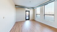Located at 520 2nd St SE in Minneapolis, MN, this one-bedroom, one-bathroom unit offers a well-designed layout that maximizes every square foot. The open-concept living, dining, and kitchen area serves as the heart of the space, featuring warm hardwood-style flooring and exposed industrial-style ductwork that runs throughout, lending a modern urban character to the interior. Natural light filters in through large windows fitted with blinds, offering views of the surrounding cityscape.

The kitchen is well-appointed with dark espresso cabinetry, stainless steel countertops, a double-basin sink, and a full suite of black appliances including a range, built-in microwave, dishwasher, and refrigerator. Upper and lower cabinets provide ample storage, complemented by open shelving for easy access.

The bedroom is a comfortable, carpeted retreat featuring floor-to-ceiling windows that bring in generous natural light and city views. A sliding-door closet offers convenient storage, and the room's neutral tones create a calm atmosphere. An additional closet elsewhere in the unit provides further storage capacity.

The bathroom is finished with tiled flooring and includes a vanity with storage. A sliding barn-style door is a stylish detail visible from the entry corridor. The unit's clean, neutral palette and functional design make it a practical and contemporary urban residence.