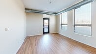 Located at 520 2nd St SE in Minneapolis, MN, this one-bedroom, one-bathroom unit offers a well-designed layout that maximizes every square foot. The open-concept living, dining, and kitchen area serves as the heart of the space, featuring warm hardwood-style flooring and exposed industrial-style ductwork that runs throughout, lending a modern urban character to the interior. Natural light filters in through large windows fitted with blinds, offering views of the surrounding cityscape.

The kitchen is well-appointed with dark espresso cabinetry, stainless steel countertops, a double-basin sink, and a full suite of black appliances including a range, built-in microwave, dishwasher, and refrigerator. Upper and lower cabinets provide ample storage, complemented by open shelving for easy access.

The bedroom is a comfortable, carpeted retreat featuring floor-to-ceiling windows that bring in generous natural light and city views. A sliding-door closet offers convenient storage, and the room's neutral tones create a calm atmosphere. An additional closet elsewhere in the unit provides further storage capacity.

The bathroom is finished with tiled flooring and includes a vanity with storage. A sliding barn-style door is a stylish detail visible from the entry corridor. The unit's clean, neutral palette and functional design make it a practical and contemporary urban residence.