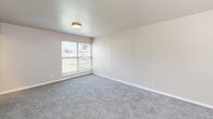 Located at 6200 Hightower Rd in Portsmouth, Virginia, this single-floor, two-bedroom, one-bathroom unit offers a practical and comfortable layout. The interior is finished with a neutral, soft gray color palette throughout, creating a clean and cohesive look.

The spacious primary bedroom is notably generous in size and features plush carpeting, a dedicated walk-in closet with a full-length hanging rod and shelf, and a window fitted with horizontal blinds that allows natural light to fill the room. The second bedroom is also carpeted and similarly bright, with its own window offering outdoor views.

The kitchen is equipped with a gas range, a range hood, light gray cabinetry, and light-toned countertops. Wood-look vinyl plank flooring runs through the kitchen and connecting areas, providing durability and easy maintenance. A window above the counter brings in additional natural light.

The full bathroom is bright and efficiently designed, featuring a white vanity with sink, a toilet, and a window with garden views. Light tile flooring completes the clean, functional aesthetic.

A hallway connects the main living areas, and the unit includes a dedicated closet for additional storage. Flush-mount ceiling lights are present throughout, and each room benefits from window blinds for privacy and light control.