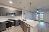 Located at 180 Jackson St NE in Atlanta's vibrant Old Fourth Ward neighborhood, this 2-bedroom, 1-bathroom unit offers a thoughtfully designed, single-floor layout with contemporary finishes throughout. The open-concept kitchen and living area serve as the heart of the home, featuring sleek gray cabinetry, a white subway tile backsplash, stainless steel Whirlpool appliances, and a striking quartz-topped peninsula with pendant lighting — ideal for both cooking and entertaining. The living room extends naturally from the kitchen and is filled with natural light courtesy of French doors that open to a private balcony, complemented by a ceiling fan overhead. Light-toned hardwood-style flooring runs seamlessly throughout the entire unit, creating a cohesive and modern aesthetic. The spacious primary bedroom offers ample room, natural light from a window, and a ceiling fan, while the second bedroom features its own window and ceiling fan as well. The shared bathroom is well-appointed with gray cabinetry, a quartz vanity countertop, a glass-enclosed shower, and modern vanity lighting. Additional spaces include a hallway, closet, and entrance, all finished with the same clean, neutral palette that defines this stylish home.