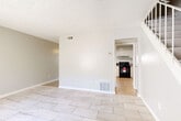 This two-story, 2-bedroom, 2-bathroom home in Moreno Valley, California offers a well-organized layout spread across two evenly balanced floors. The main level features an open living and dining area finished with light stone-look tile flooring, neutral gray walls, and a textured ceiling. A pass-through kitchen connects seamlessly to the living space, showcasing granite-style countertops, white cabinetry, a gas range, and tile flooring that extends throughout the common areas. A patio provides outdoor access directly from the main level, complementing the functional flow of the ground floor.

Upstairs, both bedrooms feature light wood-look laminate flooring and ceiling fans, creating comfortable, airy retreats. The primary bedroom is generously sized with a closet and natural light from a window. The second bedroom is equally well-appointed. Each floor is served by its own bathroom—one featuring a full tub-shower combo with elegant marble-style tile surround accented by a mosaic border strip and a window for natural light, while the second bathroom offers a compact, efficient design. Additional highlights include multiple closets throughout, in-unit laundry, a hallway connecting the upper-level rooms, and two staircases for convenient access. The overall aesthetic is clean, bright, and move-in ready.