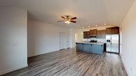 Located on N Horn Lane in Springdale, Arkansas, this single-story home offers a well-designed open-concept layout with consistent wood-look plank flooring running throughout. The living area is generously proportioned, with recessed lighting and a ceiling fan providing both comfort and functionality. It flows seamlessly into the kitchen, making the space ideal for everyday living and entertaining.

The kitchen is a standout feature, equipped with rich dark wood cabinetry, light granite countertops, and a suite of stainless steel appliances including a gas range, microwave, and French door refrigerator. A large center island with a built-in sink and granite surface adds additional workspace and a natural gathering point.

The bedrooms are well-sized, each featuring ceiling fans and wood-look flooring. One bedroom includes a window with natural light and access to a closet, while another offers a walk-in closet with built-in shelving and hanging rods for organized storage.

The bathroom includes a double-sink vanity with granite countertops, dark cabinetry, a large wall mirror, and a walk-in shower. A dedicated laundry room with side-by-side washer and dryer adds practical convenience to the home's overall design.