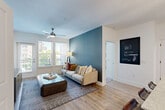 Located at 230 Bill Kennedy Way SE in Atlanta's vibrant Eastside neighborhood, this well-appointed 2-bedroom, 2-bathroom residence offers a thoughtfully designed single-level layout. The open-concept living, dining, and kitchen area serves as the heart of the home, featuring warm hardwood-style flooring, a striking teal accent wall, and a ceiling fan that enhances the bright, airy atmosphere. Large windows invite abundant natural light and offer neighborhood views, while a private balcony extends the living space outdoors.

The kitchen is a standout, boasting a granite-topped island with bar seating and pendant lighting, two-tone cabinetry in white and charcoal gray, stainless steel appliances including a French door refrigerator, and a stylish hexagonal tile backsplash. A pantry and dedicated laundry area add practical convenience.

Both bedrooms feature plush carpeting, ceiling fans, and teal accent walls that create a cohesive design thread throughout the home. The generously sized primary bedroom includes a closet for ample storage. The two bathrooms mirror the kitchen's refined aesthetic with granite vanity countertops, white cabinetry, large-format tile flooring, soaking tubs, and backlit mirrors, delivering a polished, spa-like feel.