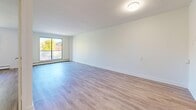 Located at 498 Queens Ave in London, Ontario, this well-appointed one-bedroom, one-bathroom unit offers a thoughtfully designed layout across a single floor. Light-toned luxury vinyl plank flooring runs throughout, lending a clean, cohesive aesthetic to every room.

The entrance opens into a hallway lined with closet storage, leading naturally into the combined dining and living area. This open-concept space is generously sized, bathed in natural light through a large sliding window that also provides direct access to a private balcony. The balcony overlooks a lush canopy of mature trees, offering a peaceful outdoor retreat.

The galley-style kitchen features white cabinetry, subway tile backsplash, stainless steel appliances including a refrigerator, and ample counter and storage space efficiently arranged along both sides of the corridor.

The bedroom is a comfortable, well-proportioned room with a window framing greenery outside, a dedicated closet with sliding doors, and a baseboard heating unit. The clean white walls and natural light create a calm, restful atmosphere.

The bathroom is finished in crisp white subway tile surrounding a full soaker tub and shower combination with chrome fixtures, complemented by a modern toilet and clean, minimalist design. The overall ambiance of the unit is bright, fresh, and move-in ready.