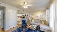 Located at 4 Village Row in Beaufort, SC, this single-floor, 2-bedroom, 2-bathroom residence offers a thoughtfully designed open-concept layout that maximizes comfort and functionality. The living room serves as the heart of the home, featuring light wood-look flooring, ceiling fans, and large windows dressed with sheer white curtains that invite generous natural light. The space flows seamlessly into the kitchen, which is equipped with crisp white cabinetry, granite countertops, stainless steel appliances including a refrigerator, range, and microwave, a subway tile backsplash, and an open breakfast bar that doubles as a casual dining area. Both bathrooms are finished with granite vanity countertops, white cabinetry, and clean, neutral tiling, offering a polished and functional aesthetic. The primary bedroom is a comfortable retreat with plush carpeting, a ceiling fan, and well-sized windows, while the second bedroom mirrors the same cozy character. A dedicated entrance, closet, and consistent neutral color palette throughout the home create a cohesive and welcoming atmosphere. The overall design balances modern finishes with practical living in the heart of Beaufort's Lowcountry.