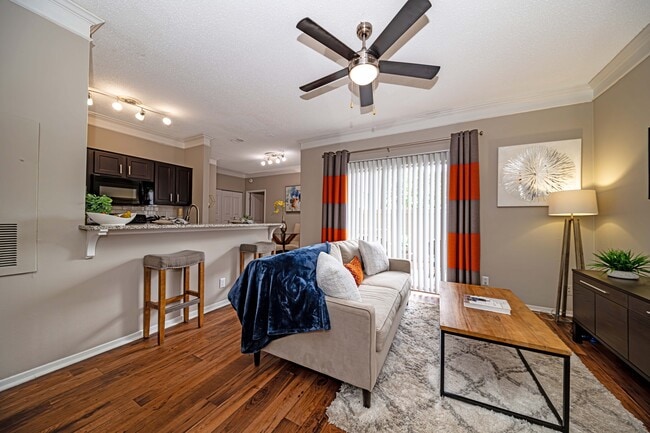 Spacious living room with hardwood-style flooring - The Indigo at Grissom