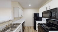 This single-story, 2-bedroom, 2-bathroom residence in Horn Lake, Mississippi, offers a clean and functional layout designed for comfortable everyday living. Light wood-look flooring flows consistently throughout the entire home, creating a cohesive and bright aesthetic across every room.

The kitchen is a standout feature, fitted with white cabinetry accented by black hardware, white marble-look countertops, a double stainless steel sink, and black appliances including a refrigerator, electric range, built-in microwave, and dishwasher. Recessed lighting illuminates the galley-style space efficiently.

Both bedrooms are generously sized and bathed in natural light through window treatments with exterior views. Ceiling fans with light fixtures are installed in the bedrooms, providing both comfort and additional illumination. The living area also features a ceiling fan and a large window that brings in ample natural light.

The two bathrooms are finished with white vanities, light countertops, and wood-look flooring that maintains visual continuity with the rest of the home. One bathroom includes a shower-tub combination, while both offer clean, neutral finishes with chrome hardware accents.

Overall, the home presents a bright, move-in-ready interior with a neutral color palette and consistent modern detailing throughout.