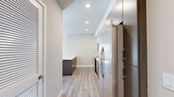 Located in the heart of Los Angeles on W 14th Street, this modern 2-bedroom, 2-bathroom unit offers a well-designed single-floor layout with a clean, contemporary aesthetic throughout. Wood-style plank flooring runs seamlessly across the entire space, complementing the neutral warm-toned walls and crisp white trim.

The open-concept kitchen and living area serves as the central hub of the unit. The kitchen is outfitted with a full suite of stainless steel appliances — including a French door refrigerator, electric range, built-in microwave, and dishwasher — paired with two-tone cabinetry featuring dark wood lower cabinets and white upper cabinets. A light gray subway tile backsplash and quartz countertops complete the polished look.

Both bedrooms are generously proportioned, filled with natural light from large windows that frame views of the surrounding Los Angeles cityscape. The spacious primary bedroom features floor-to-ceiling windows that flood the room with sunlight. Each bedroom is served by its own bathroom, both appointed with dark wood vanities, quartz countertops, large mirrors, and wood-style tile flooring. The unit also includes a dedicated laundry area, a hallway, five closets for ample storage, and a private balcony.