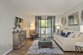 This thoughtfully laid-out 3-bedroom, 1-bathroom residence offers a comfortable and functional single-floor living experience. The bright living room serves as the heart of the home, featuring warm hardwood-style flooring, a textured ceiling, and large sliding glass doors that open to a private balcony, flooding the space with natural light. A dedicated dining area with matching hardwood-style floors provides an intimate setting for meals, accented by neutral walls that complement a variety of décor styles. The galley-style kitchen is efficiently designed with white cabinetry, light countertops, a tile backsplash, and stainless steel appliances, maximizing both storage and workspace. The generously sized primary bedroom features plush carpet, ample natural light from a large window, and direct access to a dedicated walk-in closet with dual hanging rods. Two additional carpeted bedrooms offer flexibility for guests, a home office, or family use. The full bathroom is finished with wood-style flooring, a white vanity with storage, and a shower-tub combination. Hallways connect the rooms efficiently, contributing to a smooth and practical flow throughout the residence.
