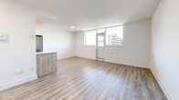 Located at 90 Eastdale Ave in Toronto's East End, this well-appointed one-bedroom, one-bathroom unit offers a thoughtfully designed layout across a single floor. Light-toned hardwood flooring runs throughout, creating a cohesive, bright, and airy atmosphere. The open-concept living and dining area is generously proportioned, bathed in natural light from large windows that frame urban views of the surrounding neighbourhood. A sliding door leads to a private balcony, extending the living space outdoors. The modern kitchen features two-tone cabinetry — warm wood lower cabinets paired with sleek white upper cabinets — complemented by a stone-look countertop, white tile backsplash, and stainless steel appliances including a range and built-in microwave. The bedroom offers a comfortable footprint, a large sliding-door closet, and a secondary closet for additional storage, with natural light from a dedicated window. The bathroom is finished in crisp white tile surrounding a full soaker tub and shower combination. An entrance area and three closets throughout the unit provide practical storage solutions, completing this clean, contemporary home.