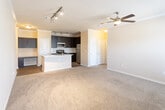 Located at 5801 Deauville Blvd in Midland, Texas, this single-floor residence offers a well-designed open-concept layout that seamlessly connects the kitchen and living areas. The kitchen is a standout feature, showcasing rich dark cabinetry, light granite countertops, a subway tile backsplash, and a full suite of stainless steel appliances including a refrigerator, gas range, microwave, and dishwasher. A central kitchen island with an integrated sink provides additional prep space and serves as a natural dividing point between the kitchen and the living area. The living space is finished with plush wall-to-wall carpeting, crown molding, and a ceiling fan, creating a comfortable and well-appointed environment. Track lighting adds a modern touch and provides versatile illumination throughout. Natural light filters in through windows fitted with horizontal blinds, offering views of the surrounding exterior. The bathroom is thoughtfully appointed with wood-look flooring, a tub and shower combo with tile surround, a dark-cabinet vanity with granite countertop, and overhead lighting. Adjacent to the bathroom, a spacious walk-in closet provides generous storage. Crown molding is carried consistently throughout the unit, contributing to a cohesive and refined aesthetic overall.