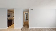 This single-floor South Carolina residence offers a clean, neutral design with a practical and well-organized layout. The open living and dining area is finished with a combination of light wood-look flooring and tile, creating a bright and cohesive feel. Large windows allow natural light to filter in, enhancing the airy atmosphere of the main living space. A dedicated entry area with a solid white door provides a welcoming arrival point.

The kitchen is thoughtfully appointed with gray cabinetry featuring matte black hardware, granite-look countertops, a subway tile backsplash, and a stainless steel undermount sink with a black faucet. Light ceramic tile flooring completes the kitchen's clean, contemporary aesthetic.

A central hallway connects the living areas to the private rooms, which are finished with plush carpet and equipped with ceiling fans for year-round comfort. The neutral gray walls throughout create a versatile backdrop adaptable to a variety of décor styles.

The bathroom includes a full tub-shower combination with clean white surrounds, complemented by matte black fixture accents that tie into the home's consistent design language. Textured ceilings are present throughout, adding subtle dimension to each room. Overall, this residence presents a tidy, move-in ready space with cohesive finishes from entry to end.