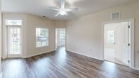 Located at 11670 Hokie Stone Loop in Manassas, VA, this well-appointed one-bedroom, two-bathroom residence offers a thoughtfully designed single-floor layout. The open-concept kitchen and living area serves as the heart of the home, featuring rich cherry wood cabinetry, granite countertops, stainless steel appliances including a refrigerator, dishwasher, and range, and durable wood-style flooring that extends throughout the main living spaces. The living room is bright and airy, enhanced by vaulted ceilings, a ceiling fan, and multiple windows that invite abundant natural light and offer views of the surrounding community's landscaped grounds. The spacious primary bedroom is carpeted for comfort, includes a ceiling fan, and benefits from generous natural light through large windows. A walk-in closet with built-in wire shelving provides ample storage. Both bathrooms are finished with granite-topped vanities and wood-style flooring, with one featuring a full soaking tub and shower combo. A dedicated laundry area houses a stacked washer and dryer unit for added convenience. A private balcony offers outdoor enjoyment with views of the green community surroundings.