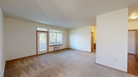 Located in Spokane, WA, this two-story home offers a practical and comfortable layout with two bedrooms, two full bathrooms, and an attached garage. The main living level is generously sized, hosting an open-concept area that combines the living room, dining room, and kitchen. The living room is carpeted and filled with natural light through large windows and a glass door that frames views of surrounding greenery. The kitchen features warm wood cabinetry, hardwood-style flooring, ample counter space, and a full suite of appliances including an electric range, refrigerator, microwave, and dishwasher. Both bedrooms are carpeted and bright, each with access to natural light. The primary bedroom includes a spacious walk-in closet outfitted with wire shelving on multiple walls, offering excellent storage capacity. Three closets in total are distributed throughout the home. The two bathrooms are finished with tile flooring and include tub/shower combinations and warm wood vanities. A dedicated laundry area houses an in-unit washer. The attached garage features a concrete floor and automatic opener. Carpeted staircases with wood handrails connect the levels, completing this well-appointed Spokane residence.