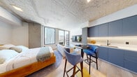 Located on the 20th floor at 307 SW 5th St in the heart of Fort Lauderdale, this thoughtfully designed one-bedroom, one-bathroom residence offers an efficient yet stylish urban living experience. The open-concept main area seamlessly integrates the living room, dining space, and kitchen into a single cohesive zone, anchored by striking exposed concrete ceilings that lend an industrial-modern character throughout. Light oak hardwood flooring runs continuously underfoot, complementing the neutral palette.

The kitchen is outfitted with sleek slate-blue cabinetry, under-cabinet lighting, stainless steel appliances, and a compact island with bar seating — ideal for casual dining. The living area opens directly onto a private balcony through floor-to-ceiling sliding glass doors, framing sweeping Fort Lauderdale skyline views and flooding the space with natural light.

The bedroom is a calm, well-defined retreat, accommodating a full-sized bed with room to spare, and benefits from access to two closets for ample storage. The bathroom features large-format stone-look wall tiles, a glass-enclosed walk-in shower with mosaic tile flooring, and a wall-mounted vanity with a lighted mirror. A dedicated laundry area and utility room round out the practical amenities of this polished high-rise residence.