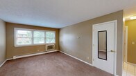 Located at 706 Arcadia #5 in Bloomington, IL, this two-bedroom, one-bathroom unit offers a practical and well-organized single-floor layout. The combined kitchen and living area forms the heart of the home. The kitchen is equipped with rich, dark wood cabinetry arranged in an L-shape, offering generous storage and counter space. A white gas range, stainless steel refrigerator, and dishwasher are included, complemented by tile flooring and a tiled backsplash. The spacious living room features warm beige carpet, neutral tan walls, and windows that allow natural light to filter in, along with a wall-mounted air conditioning unit and baseboard heating. Both bedrooms are carpeted and feature ceiling fans with light fixtures and dual bi-fold closets providing ample storage. The primary bedroom is a comfortable size, while the second bedroom includes a window with outdoor views and baseboard heating. The full bathroom is finished with white tile flooring, a full-width vanity with a large mirror, and a clean, bright aesthetic. Throughout the unit, neutral tones and consistent finishes create a cohesive and functional living environment suitable for everyday comfort.