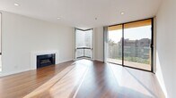 Located at 7275 Franklin Ave in Los Angeles, CA, this well-appointed one-bedroom, one-bathroom residence offers a thoughtfully designed layout across a single floor. Rich hardwood flooring flows through the main living areas, complemented by clean white walls and abundant natural light streaming in through large windows and sliding glass doors.

The open-concept living room features a cozy fireplace and a stylish ceiling fan, creating a comfortable and functional gathering space. A sliding glass door leads to a private balcony with teal railings, offering pleasant views of the surrounding Los Angeles cityscape, palm trees, and neighboring buildings under sunny California skies.

The kitchen is well-equipped with rich dark wood cabinetry, light stone countertops, a mosaic tile backsplash, stainless steel appliances including a gas range, and a peninsula that connects seamlessly to the living area. Tile flooring in the kitchen provides a clean contrast to the hardwood in the adjacent rooms.

The bedroom is a bright, carpeted retreat with a large window that invites natural light and outdoor views. Three closets throughout the unit provide generous storage. The bathroom features rich wood vanity cabinetry, a dual-sink countertop, large mirrors, tile flooring, and a separate water closet with a shower-tub combination.
