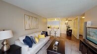 Located at 7800 Woodman Ave in the Panorama City neighborhood of Los Angeles, this single-floor residence offers a well-organized and functional layout designed for comfortable everyday living. The entryway, finished with rich dark hardwood-style flooring, leads into the main living areas and sets a welcoming tone throughout.

The carpeted living room is bright and open, featuring a large picture window that draws in natural light and provides a view of the surrounding greenery. A wall-mounted air conditioning unit ensures year-round comfort. The space flows seamlessly into the dining area and kitchen, which is equipped with white cabinetry, a gas range, refrigerator, and granite-style countertops. A breakfast bar with bar stools connects the kitchen to the living area, while a ceiling fan overhead adds to the airy feel of the combined dining and kitchen space.

The bedroom is generously proportioned, featuring plush carpet flooring, a window with outdoor views, and ample room for a full furniture suite. The bathroom is clean and well-appointed, offering a vanity with granite-style counters, white cabinetry, and convenient direct access to the bedroom. Throughout the residence, textured ceilings and neutral wall tones create a cohesive and inviting atmosphere.