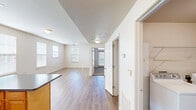 Located in New Orleans, LA 70115, this single-story, one-bedroom, one-bathroom unit offers a functional and comfortable layout designed to maximize everyday living. The open-concept living and dining area features warm wood-tone laminate flooring, white walls, and a ceiling fan, creating a bright and airy atmosphere. Multiple windows fitted with horizontal blinds allow natural light to flow throughout the space, offering pleasant views of the surrounding greenery.

The kitchen is a standout feature, equipped with warm-toned wood cabinetry, dark countertops, a tile backsplash, and a full suite of white appliances including a refrigerator, range, microwave, and dishwasher. A central island provides additional prep space and casual seating. The kitchen connects seamlessly to the main living area, making it well-suited for everyday use.

The bedroom is a comfortable, well-lit room with laminate flooring, a ceiling fan, and multiple windows that bathe the space in natural light. The full bathroom features tile flooring, a wood-cabinet vanity with a light countertop, and a tub and shower combination. A dedicated in-unit laundry area with full-size washer and dryer hookups adds a practical and convenient amenity to this well-rounded New Orleans residence.