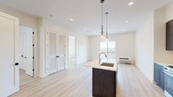 This thoughtfully designed two-bedroom, two-bathroom unit at 487 Market Street in Saddle Brook, NJ offers a well-organized single-level layout with modern finishes throughout. The open-concept kitchen serves as a central highlight, featuring dark espresso cabinetry extending to the ceiling, white quartz countertops, a center island with an undermount sink, stainless steel appliances, and globe pendant lighting — all set above light-toned hardwood-style flooring that runs continuously through the living areas and bedrooms.

The living area connects seamlessly to a private balcony through sliding glass doors, allowing natural light to fill the space and offering outdoor views of the surrounding neighborhood. Both bedrooms are bright and neutrally finished, each equipped with individual PTAC heating and cooling units and windows that bring in additional daylight. The primary bedroom benefits from a dedicated walk-in closet outfitted with a full built-in shelving and hanging system for organized storage.

The two bathrooms feature floor-to-ceiling large-format neutral tile, with one bathroom offering a soaking tub enclosed by a glass panel and textured tile surround, while the other includes a walk-in shower. Both bathrooms are finished with warm wood vanities and marble-style countertops, complementing the unit's clean, contemporary aesthetic.