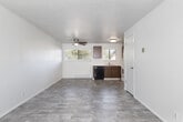 Located at 509 S 13th St in Boise, Idaho, this two-floor residential space offers a straightforward and functional layout across multiple rooms. The kitchen is well-equipped with warm wood-toned cabinetry, light countertops, and a full suite of appliances including an electric range, over-the-range microwave, dishwasher, and refrigerator. Natural light filters in through a window above the sink, and the space features light wood-look flooring for easy maintenance. The living area is generously proportioned, featuring the same light-toned flooring, a textured ceiling, and a baseboard heating unit beneath a window fitted with blinds, creating a bright and open atmosphere. The bedrooms are carpeted for comfort, with neutral walls, closet storage, and ceiling fans in select rooms. Windows dressed with blinds allow natural light while maintaining privacy. The bathroom has been updated with large-format grey tile surrounding a soaking tub and shower combination, complemented by a white vanity and wood-look flooring, lending a clean, modern feel. Baseboard heating is present throughout the space, ensuring warmth during Boise's colder months. Overall, the space presents a clean, functional environment suitable for everyday living.