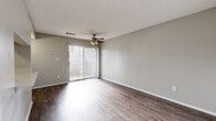 Located in Austin, TX (78759), this single-floor studio is thoughtfully designed to maximize functionality within a compact footprint. The open-concept living and kitchen area serves as the heart of the space, featuring rich, dark hardwood-style flooring that runs throughout the unit. The living area is brightened by a large sliding glass door fitted with vertical blinds, allowing an abundance of natural light to fill the room. A ceiling fan with a light fixture adds both comfort and practicality overhead, while a textured ceiling adds a layer of architectural detail.

The kitchen is outfitted with crisp white cabinetry, light stone countertops, and black appliances, creating a clean and modern aesthetic. A window with horizontal blinds provides additional natural light to the space.

The bathroom is well-appointed with a white vanity, light stone countertop, a matte black faucet, a large mirror with overhead lighting, and a full bathtub and shower combo — all finished in a neutral, cohesive palette consistent with the rest of the unit.

A dedicated walk-in closet offers built-in shelving and hanging rods, providing ample storage. A hallway connects the various areas of the studio, contributing to a logical and efficient flow throughout the space.