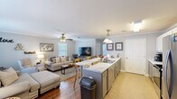 This single-floor, two-bedroom, two-bathroom residence in Lafayette, Louisiana offers a well-designed open-concept layout that maximizes its functional living space. The kitchen serves as a central hub, featuring a large peninsula with striking marble-look countertops, gray lower cabinets paired with white upper cabinets, stainless steel appliances, and a pendant light overhead. The kitchen flows seamlessly into the living room, which is finished with warm hardwood flooring, crown molding, a ceiling fan, and natural light from multiple windows fitted with blinds.

The primary bedroom is a comfortable retreat with hardwood floors, a ceiling fan, natural light from dual windows, and generous floor space. The primary bathroom includes a dual-sink vanity with gray cabinetry, white countertops, framed mirrors, and tile flooring. The second bedroom accommodates flexible use as a guest room or home office, also featuring hardwood floors and a ceiling fan. The second bathroom offers a single vanity with matching gray cabinetry, a framed mirror, and tile floors. Throughout the unit, a consistent neutral color palette and cohesive finishes create a unified, inviting ambiance.
