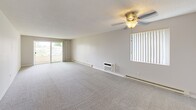 Located at 120 E Hawthorne Rd in Spokane, Washington, this three-bedroom, two-bathroom residence offers a functional and comfortable single-floor layout. The galley-style kitchen is well-appointed with dark wood cabinetry, laminate countertops, wood-look flooring, and a full suite of white appliances including a refrigerator and electric range. A single basin sink and vertical blind-covered window add practical touches to the space.

The expansive primary bedroom is notably generous in size, featuring plush wall-to-wall carpeting, a ceiling fan with light fixture, textured ceiling, and a sliding glass door that opens directly onto a private balcony with outdoor views. Additional bedrooms are carpeted and well-lit, each equipped with ceiling fans, baseboard heating, and windows that bring in natural light.

The bathrooms include a full tub-and-shower combo finished with white subway tile and light tile flooring. A connecting hallway links the rooms efficiently throughout the unit. Neutral tones, baseboard heating, and textured ceilings are consistent throughout, creating a cohesive and move-in-ready living environment suited for everyday comfort.