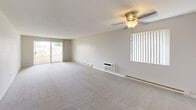 Located at 120 E Hawthorne Rd in Spokane, Washington, this three-bedroom, two-bathroom residence offers a functional and comfortable single-floor layout. The galley-style kitchen is well-appointed with dark wood cabinetry, laminate countertops, wood-look flooring, and a full suite of white appliances including a refrigerator and electric range. A single basin sink and vertical blind-covered window add practical touches to the space.

The expansive primary bedroom is notably generous in size, featuring plush wall-to-wall carpeting, a ceiling fan with light fixture, textured ceiling, and a sliding glass door that opens directly onto a private balcony with outdoor views. Additional bedrooms are carpeted and well-lit, each equipped with ceiling fans, baseboard heating, and windows that bring in natural light.

The bathrooms include a full tub-and-shower combo finished with white subway tile and light tile flooring. A connecting hallway links the rooms efficiently throughout the unit. Neutral tones, baseboard heating, and textured ceilings are consistent throughout, creating a cohesive and move-in-ready living environment suited for everyday comfort.