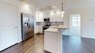 This well-appointed 2-bedroom, 2-bathroom corner unit is designed with both comfort and functionality in mind. The open-concept living and kitchen area features rich, dark hardwood flooring that flows seamlessly throughout the main living spaces. The modern kitchen is outfitted with white shaker cabinetry, a subway tile backsplash, stainless steel appliances including a French door refrigerator, a gas range, and a built-in microwave. A peninsula with a light quartz countertop and pendant lighting above provides an ideal space for casual dining or entertaining. A built-in shelving unit near the entry adds convenient storage.

Both bedrooms are generously sized, carpeted for comfort, and filled with natural light from large windows. The primary bedroom features a ceiling fan, hardwood flooring, a walk-in closet, and direct access to the hallway. The second bedroom benefits from corner-unit windows on two sides, offering expansive views and bright natural light.

Each bathroom is finished with light tile flooring, white vanity cabinetry with brushed nickel hardware, and a tub-shower combination with decorative tile accents. The primary bath also features a large window for added brightness, creating a clean and airy atmosphere throughout.