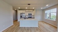 This contemporary apartment, situated at 2611 Hopps Rd. in Elgin, IL, offers 1610 square feet of thoughtfully designed living space. The single-floor layout encompasses two bedrooms, including a generous 210 square foot primary bedroom, and three full bathrooms. The heart of the home is an open-concept kitchen and living area, showcasing a gourmet kitchen with sleek white cabinetry, stainless steel appliances, and a large center island with a modern pendant light fixture. The kitchen seamlessly flows into the living room, creating an ideal space for entertaining. Large windows throughout provide ample natural light and views of the surrounding area. The bedrooms feature plush carpeting for comfort, while the main living areas boast elegant light-toned hardwood floors. The bathrooms are finished with modern fixtures and ample storage space. Additional amenities include spacious closets with built-in organizers, recessed lighting, and a neutral color palette that allows for personalized decor. This apartment combines style and functionality, offering a perfect blend of comfort and modern living.