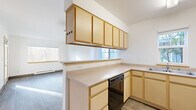 Located at 3114 Racine St in Bellingham, WA, this single-floor residence offers three bedrooms and two full bathrooms within a efficiently designed layout. The open-concept kitchen and living area serves as the heart of the home, featuring light wood cabinetry with ample upper and lower storage, a peninsula counter that separates the kitchen from the living space, and white appliances including a range and refrigerator. Wood-look flooring runs throughout the main living areas, adding warmth and continuity to the space. A glass-paneled exterior door in the living room allows natural light to fill the area and provides direct access to an outdoor patio or walkway. The primary bedroom is a well-proportioned room featuring a large window with views of surrounding greenery, a baseboard heater, and generous natural light. The secondary bedrooms are carpeted and each include built-in closets with sliding doors, offering practical storage solutions. The two bathrooms are clean and functional — one features a standalone walk-in shower with full surround, while the other includes a soaking bathtub with surround. Both bathrooms are finished with wood-toned vanity cabinetry and wood-look tile flooring, maintaining a cohesive aesthetic throughout the home.