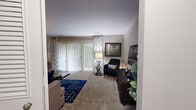This well-appointed 2-bedroom, 2-bathroom residence in Towson, MD offers a thoughtfully designed single-floor layout with generous living spaces. The expansive living room is bathed in natural light from large sliding glass doors fitted with vertical blinds and decorative curtains, opening to an outdoor view. Plush carpeting and neutral wall tones create a warm, inviting ambiance throughout. Adjacent to the living room, a dedicated dining room features a pendant light fixture and a bright window, providing an ideal space for entertaining. The combined dining and living area offers additional flexibility for everyday living. The kitchen is a standout feature, showcasing white cabinetry, granite-style countertops, a classic subway tile backsplash, stainless steel appliances including a gas range, microwave, and dishwasher, and durable wood-look flooring. The spacious primary bedroom includes plush carpeting, natural light from a large window, and ample room for a full furniture arrangement. The second bedroom is equally versatile, ideal as a guest room or home office. Both bathrooms are well-finished, with one featuring a full soaking tub and shower combination. Six closets provide exceptional storage, and an in-unit laundry area adds convenience.