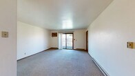 Located at 2209 Michelle Ct in Appleton, Wisconsin, this single-floor, 2-bedroom, 1-bathroom residence offers a practical and well-organized layout. The living area is carpeted and bright, featuring a sliding glass door that opens to a private balcony overlooking outdoor greenery, allowing natural light to fill the space. Baseboard heating is present throughout, providing efficient warmth suited to Wisconsin's climate. The kitchen is equipped with warm-toned wood cabinetry, light countertops, and a stainless electric range, all complemented by durable hardwood-style flooring that adds a clean, functional aesthetic. The primary bedroom offers a comfortable footprint with a double sliding-door closet, a window with blinds, and carpeted flooring. The second bedroom is similarly carpeted and well-lit, featuring a ceiling fan with light fixture, a window, and a baseboard heater. Both bedrooms include wood-toned closet doors consistent with the home's interior design language. The full bathroom features a single-sink vanity with wood cabinetry, a tub-shower combination, and hardwood-style flooring. Throughout the home, warm wood accents on doors and trim provide a cohesive and inviting atmosphere.