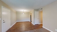 This single-story residence offers a well-organized layout that balances comfort and functionality throughout its living spaces. The main living and dining area is an open, airy space featuring rich hardwood-style flooring, neutral-toned walls, and a textured ceiling. A pendant light fixture serves as a central focal point, while natural light filters in through a window and glass door entry, creating a welcoming atmosphere. The transition between the carpeted and hard-floored zones subtly delineates the living and dining areas.

The kitchen has been thoughtfully updated with crisp white shaker-style cabinetry, granite countertops, a classic subway tile backsplash, and a full suite of stainless steel appliances including a range, dishwasher, and refrigerator. A stainless steel sink with a modern faucet completes this functional cooking space.

The bedroom is a comfortable, carpeted retreat with a ceiling fan, a louvered closet door offering generous storage, and neutral walls that lend a calm ambiance. The bathroom features hardwood-style flooring, a full tub and shower combination, a granite-topped vanity, and a louvered closet, maintaining a clean and cohesive aesthetic throughout. Overall, the unit presents a tidy, move-in-ready character with consistent finishes across all rooms.