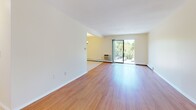 Located at 42 Bayberry Cir in Clicquot, MA, this single-floor unit offers a well-organized layout with warm hardwood flooring throughout the main living areas. The open living and dining space is bright and inviting, anchored by a chandelier and connected seamlessly to the kitchen via an open pass-through design. Sliding glass doors lead to a balcony overlooking lush greenery, bringing natural light and outdoor views into the main living area.

The galley-style kitchen is efficiently designed, featuring honey-toned wood cabinetry, dark granite countertops, a mosaic tile backsplash, and light tile flooring. White appliances, including a refrigerator, range, and dishwasher, complete the space. A closet near the entry provides convenient storage.

The bedrooms continue the hardwood flooring theme, with each room offering closet storage. One bedroom includes a window with a view of surrounding trees and a wall-mounted air conditioning unit. The bathroom features sage-green subway tile surrounding the tub and shower, a mosaic tile floor, a white vanity with ample counter space, and a mirrored medicine cabinet, creating a clean, classic aesthetic throughout.
