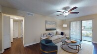 Located at 3720 Derby Dr in Palm Harbor, Florida, this single-floor residence offers a thoughtfully designed layout with a cohesive, comfortable aesthetic throughout. The living room serves as the heart of the home, featuring rich hardwood-style flooring, a ceiling fan, and sliding glass doors with vertical blinds that open to an outdoor view, filling the space with natural light. The dining area continues the warm, inviting feel with hardwood-style flooring, a pendant light fixture, and a window framed by stylish drapes that allow natural light to pour in. The kitchen is well-equipped with warm wood cabinetry, granite countertops, stainless steel appliances including a range and over-the-range microwave, and a decorative tile backsplash that adds a modern touch. The bedrooms are carpeted and each includes a ceiling fan, providing a cozy retreat. The primary bedroom is generously proportioned, while the secondary bedroom also offers ample space with a bright window. A bathroom with hardwood-style flooring rounds out the interior. Throughout the residence, neutral wall tones create a calm, versatile backdrop, and textured ceilings add a classic Florida residential character to every room.