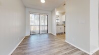 Located at 2074 Forest Hill Rd in Macon, Georgia, this single-floor unit offers a clean, modern interior with a thoughtfully designed layout. Throughout the main living and common areas, light wood-style luxury vinyl flooring creates a cohesive and contemporary aesthetic, while crisp white walls and neutral tones contribute to a bright, airy atmosphere.

The living area is welcoming and well-lit, featuring a front entry door with a sidelight window and access to a sliding glass door that opens to an outdoor patio, allowing natural light to flow freely through the space. The kitchen is efficiently designed with white cabinetry, a tile backsplash, and a suite of appliances including a black electric range, black refrigerator, and stainless steel dishwasher — providing both style and functionality.

The bedrooms feature plush carpeting, ceiling fans, and windows with blinds that offer views of the surrounding greenery. Each bedroom includes closet storage, with at least one bedroom offering a dedicated closet space. The bathroom is finished with light wood-style flooring, a white vanity with an illuminated mirror, and louvered closet doors that add a classic detail to the clean, white interior. Overall, the space presents a well-maintained and move-in ready environment.