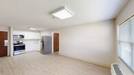 This 1-bedroom, 1-bathroom unit offers a clean, modern layout across a single floor. Light wood-style flooring runs throughout the entire space, contributing to a bright and cohesive aesthetic. The open living area is generously sized, featuring textured ceilings, flush panel lighting, and a window with blinds that allows natural light to fill the room. A wall-mounted PTAC unit provides climate control convenience directly in the living space.

The kitchen is efficiently designed with white shaker-style cabinetry, light countertops, a stainless steel refrigerator, electric range with over-the-range microwave, and a undermount sink — all finished with a clean, contemporary look and overhead panel lighting.

The spacious primary bedroom features a window with blinds, a wall-mounted PTAC unit, and ample room for furnishings. Its neutral walls and light flooring create a calm, restful environment.

The bathroom is finished with a white shaker vanity, white quartz-style countertop, a rectangular undermount sink with brushed nickel faucet, a large mirror with lighted bar fixture, tiled shower surround, and matching light flooring. The overall design of the unit is neutral, clean, and move-in ready.
