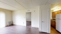 Located at 7517 North 40th Street in Tampa, FL, this single-story, one-bedroom, one-bathroom unit offers a practical and straightforward layout across a single floor. The combined living and dining area serves as the heart of the home, showcasing durable wood-look flooring that runs throughout the space. Painted concrete block walls lend a sturdy, low-maintenance character, while textured drop ceilings complete the interior aesthetic. Natural light enters through large windows fitted with vertical blinds, and a sliding glass door provides an outdoor view and additional brightness to the living area.

The kitchen is efficiently laid out and includes wooden cabinetry and a white refrigerator, offering essential storage and appliance space. The bedroom is a comfortable size, featuring the same wood-look flooring, a window with vertical blinds for natural light, and easy access to a dedicated closet. The bathroom is well-appointed with a full tub-shower combination finished with white subway-style tile, safety grab bars, wood-toned vanity cabinetry with a granite-look countertop, and matching wood-look flooring that ties the space together. Throughout the unit, the neutral color palette and clean finishes create a bright, functional living environment.