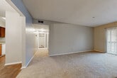This single-story residence features two bedrooms and two bathrooms within a practical, well-organized floor plan. The living room is carpeted and spacious, anchored by a tile-surround fireplace and access to a sliding glass door with vertical blinds. A textured ceiling is consistent throughout the common areas, adding subtle dimension overhead. Adjacent to the living room, the dining area is defined by warm hardwood-style flooring and an elegant chandelier, creating a distinct space for meals and entertaining.

The kitchen is equipped with warm oak cabinetry, light speckled countertops, a double-basin sink, a dishwasher, a white electric range, and a full-size refrigerator. Hardwood-style flooring continues through this functional cooking space, which connects conveniently to the dining area via a pass-through opening.

Both bedrooms are carpeted and feature neutral gray walls with ample room for furnishings. One bedroom includes a window with exterior views, while the other provides easy hall access. A hallway with closet storage connects the bedroom wing to the rest of the unit. The bathrooms include oak vanities with light countertops, large mirrors, and hardwood-style flooring, maintaining a cohesive design throughout.