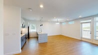 Located at 4130 High Mountain Rd NE in Huntsville, Alabama, this well-appointed 2-bedroom, 2-bathroom home offers a thoughtfully designed single-level layout with a clean, modern aesthetic throughout. Light hardwood-style flooring flows seamlessly across every room, complementing the crisp white walls and creating a bright, cohesive interior.

The open-concept living room serves as the heart of the home, anchored by a striking shiplap-clad fireplace and flanked by large windows and glass doors that frame lush, rolling outdoor views. Recessed lighting enhances the airy atmosphere of this generously sized gathering space.

The kitchen is a standout feature, boasting a large granite-topped island with a double basin sink, sleek stainless steel appliances, white upper cabinetry, contrasting lower cabinets, a classic subway tile backsplash, and stylish black pendant lighting — ideal for both cooking and entertaining.

Both bedrooms are well-proportioned and filled with natural light from sizable windows fitted with blinds. Ceiling fans are present in the bedrooms, adding comfort and practicality. The primary bedroom offers ample space with access to additional rooms.

The two bathrooms are finished in a modern style. One features a blue-grey vanity with a dark countertop and wall-mounted storage, while the other includes a full soaking tub with white tile surround and matte black fixtures throughout — a refined, cohesive design detail found across the entire home.