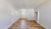 Located at 6233 S La Brea Ave in Los Angeles, CA, this well-appointed one-bedroom, one-bathroom unit offers a clean, modern aesthetic across a single floor. Light wood-toned flooring flows seamlessly throughout the entire space, lending warmth and visual continuity to every room.

The living room is a welcoming open area bathed in natural light from a front-facing window, accented by a classic pendant light fixture. A wall-mounted heating unit and crisp white walls complete the bright, airy feel of this main gathering space.

The kitchen is a standout feature, showcasing white shaker-style cabinetry, light stone countertops, and a full suite of stainless steel appliances including a gas range, built-in microwave, and dishwasher. A window above the sink brings in additional natural light.

The bedroom is a comfortable, well-lit retreat with a ceiling fan, a large window with views to the exterior, and access to two closets, providing ample storage. The bathroom features a rich dark wood vanity with generous drawer and cabinet storage, a white countertop, mirror, and a bright window for natural ventilation. A connecting hallway ties all rooms together efficiently, making the layout practical and easy to navigate.