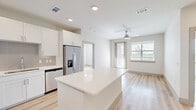 Located at 2101 S Celina Pkwy in Celina, TX, this thoughtfully designed 2-bedroom, 2-bathroom residence offers a clean, modern aesthetic throughout its single-floor layout. Light wood-tone flooring runs seamlessly across every room, creating a bright and cohesive feel that is complemented by neutral white walls and recessed lighting.

The kitchen is a standout feature, anchored by a large central island with white quartz countertops and crisp white shaker cabinetry. A full suite of stainless steel appliances — including a range, microwave, dishwasher, and refrigerator — lines the walls alongside a subtle gray tile backsplash, combining style with practicality.

Both bedrooms are well-proportioned and filled with natural light from large windows that offer open views of the surrounding landscape. Each room includes a ceiling fan and direct access to a dedicated closet. The primary bedroom connects to its own en-suite bathroom, which features a white vanity with dual sinks, ample drawer storage, and a glass-enclosed shower.

The second bathroom mirrors the same clean design with a white floating vanity, modern lighting fixtures, and a generous walk-in closet nearby. Outside, a private fenced yard with manicured landscaping extends the living space and opens to views of the open Texas sky, rounding out this well-appointed home.