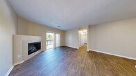 Located at 8001 E 11th Ave in Denver's desirable Park Hill neighborhood, this well-appointed 3-bedroom, 2-bathroom residence offers comfortable single-floor living with thoughtful design throughout. The open living area makes a strong first impression with rich wood-style flooring, neutral toned walls, and a tile-surround corner fireplace that anchors the space. Sliding glass doors flood the room with natural light and provide direct access to a private balcony with outdoor views. The kitchen is a standout feature, boasting crisp white shaker cabinetry, white quartz countertops, a subway tile backsplash, and a full suite of stainless steel appliances including a refrigerator, range, microwave, and dishwasher. The adjacent dining area flows naturally from the kitchen, ideal for everyday living and entertaining. Three well-sized bedrooms are carpeted for comfort, each offering ample natural light and generous closet space — with four closets total throughout the home. The primary bedroom includes an en-suite bathroom featuring a wide vanity with white cabinetry and modern lighting. The second bathroom is equally well-finished with a tub-shower combo and wood-style flooring. A dedicated laundry area and a connected hallway complete this practical and polished layout.