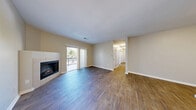 Located at 8001 E 11th Ave in Denver's desirable Park Hill neighborhood, this well-appointed 3-bedroom, 2-bathroom residence offers comfortable single-floor living with thoughtful design throughout. The open living area makes a strong first impression with rich wood-style flooring, neutral toned walls, and a tile-surround corner fireplace that anchors the space. Sliding glass doors flood the room with natural light and provide direct access to a private balcony with outdoor views. The kitchen is a standout feature, boasting crisp white shaker cabinetry, white quartz countertops, a subway tile backsplash, and a full suite of stainless steel appliances including a refrigerator, range, microwave, and dishwasher. The adjacent dining area flows naturally from the kitchen, ideal for everyday living and entertaining. Three well-sized bedrooms are carpeted for comfort, each offering ample natural light and generous closet space — with four closets total throughout the home. The primary bedroom includes an en-suite bathroom featuring a wide vanity with white cabinetry and modern lighting. The second bathroom is equally well-finished with a tub-shower combo and wood-style flooring. A dedicated laundry area and a connected hallway complete this practical and polished layout.