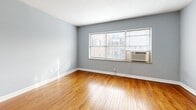 Located at 1500 E 46th St in Kansas City, MO, this one-bedroom, one-bathroom unit offers a well-organized and functional layout across a single floor. Warm-toned hardwood flooring runs throughout the living, dining, and bedroom areas, lending a classic and inviting character to the space. The soft gray walls provide a neutral, calming palette that complements the natural light streaming in through multiple windows fitted with blinds.

The living and dining areas offer an open, airy feel with room for comfortable furnishings. The bedroom is a well-proportioned retreat, featuring windows with natural views, a window-unit air conditioner, and access to ample closet storage — with four closets distributed throughout the unit providing exceptional organizational capacity.

The kitchen is efficiently designed with white cabinetry, clean countertops, and a full suite of stainless steel appliances including a gas range, microwave, and refrigerator, all set atop light wood-look flooring. The bathroom features classic white subway tile surrounding a full soaking tub, a window for natural ventilation, and crisp white fixtures. A dedicated utility room, entrance, and hallway round out the thoughtful floor plan of this Kansas City home.
