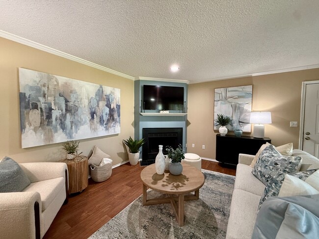 Spacious living room with hardwood-style flooring & fireplace - Vetra at Hamilton Place