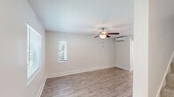Located at 144 E 61st St in Savannah, GA, this two-story, 2-bedroom, 2-bathroom home offers a well-designed layout spread across two floors. The main level hosts the kitchen and living area, while the upper floor is dedicated to the bedrooms and additional bath.

The kitchen is a standout feature, showcasing crisp white shaker cabinetry extending to the ceiling for ample storage, granite countertops, a central island with additional seating space, and a full suite of stainless steel appliances including a range, microwave, dishwasher, and refrigerator. Wood-look luxury flooring runs throughout the main level, complementing the bright, neutral color palette.

Both bedrooms are situated on the upper floor and are carpeted for comfort. The spacious primary bedroom features dual windows that invite natural light and greenery views, along with a ceiling fan. The second bedroom also includes a ceiling fan, a wall-mounted mini-split unit, and a closet. Each bathroom is cleanly finished — one includes a tub/shower combo with brushed nickel fixtures and a granite-topped vanity, while the second bath features a pedestal sink and matching hardware. The overall aesthetic is clean, modern, and move-in ready.